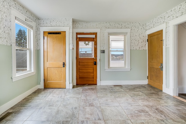 entrance foyer with wallpapered walls, visible vents, and baseboards