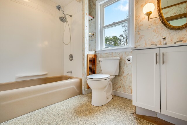 bathroom featuring toilet, baseboards, wallpapered walls, vanity, and tub / shower combination