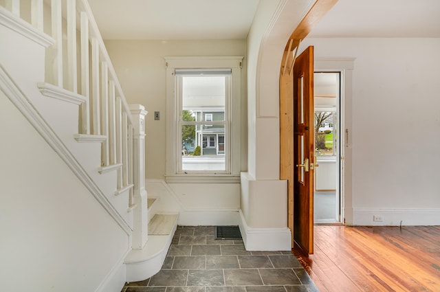 foyer with stairway, visible vents, and baseboards