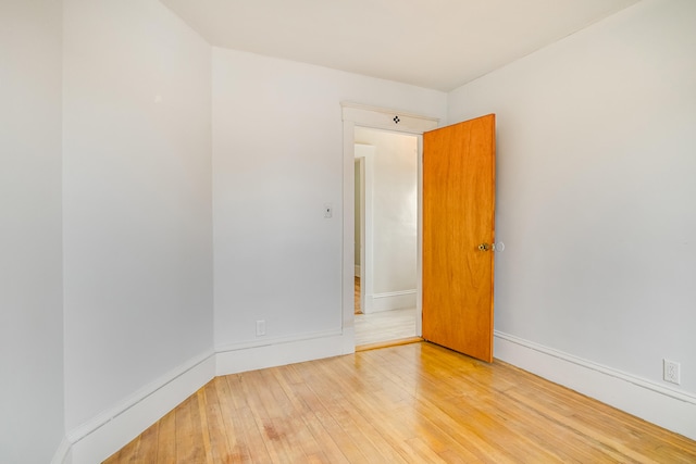 unfurnished room with baseboards and light wood-style floors