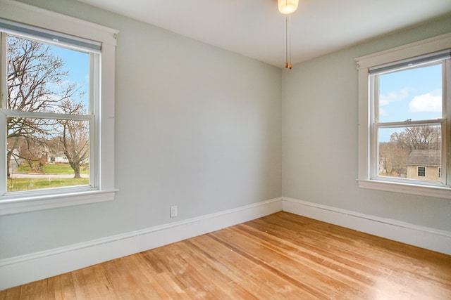 spare room featuring baseboards and wood finished floors