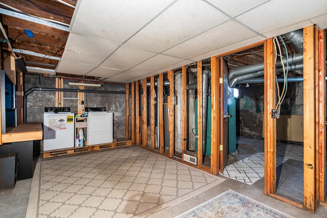 unfinished below grade area with washer / dryer and a paneled ceiling