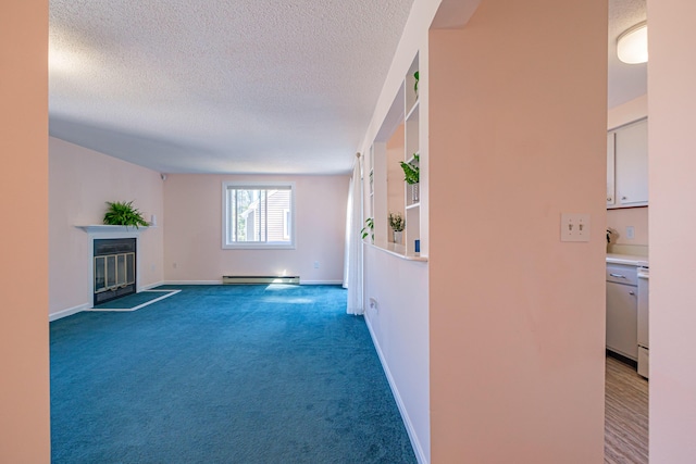 interior space featuring baseboards, a baseboard radiator, a textured ceiling, carpet floors, and a glass covered fireplace