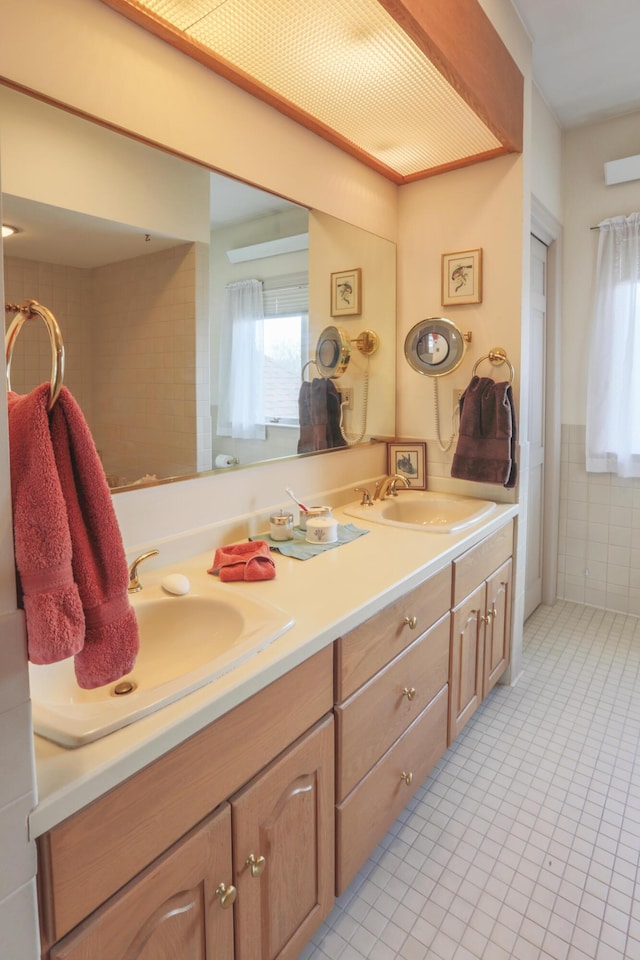 full bathroom featuring tile patterned flooring, a sink, and plenty of natural light