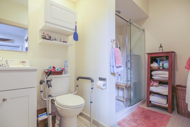bathroom featuring toilet, vanity, and a stall shower
