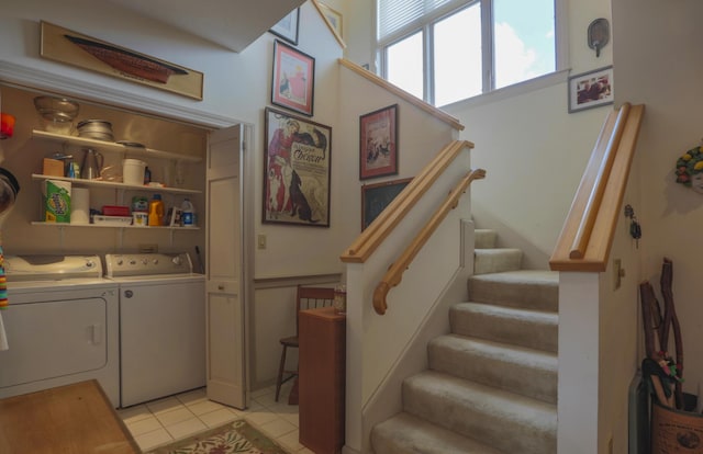 washroom featuring light tile patterned flooring, washing machine and clothes dryer, and laundry area