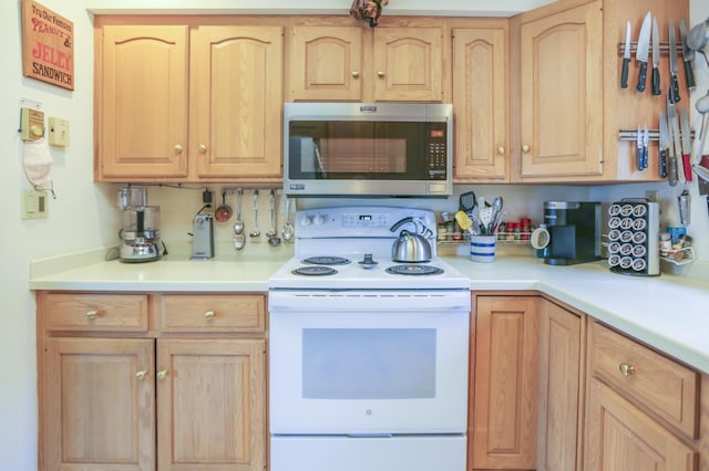 kitchen with stainless steel microwave, light brown cabinets, and white electric stove