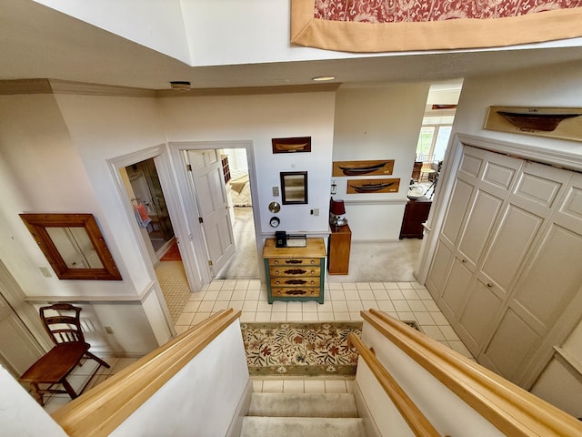 stairway with tile patterned floors, baseboards, and carpet floors