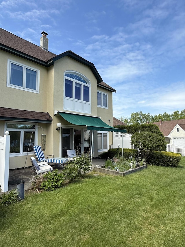 91 Dockside Ln Unit 5, Belfast, ME 04915 - back of property featuring stucco siding, a chimney, and roof with shingles