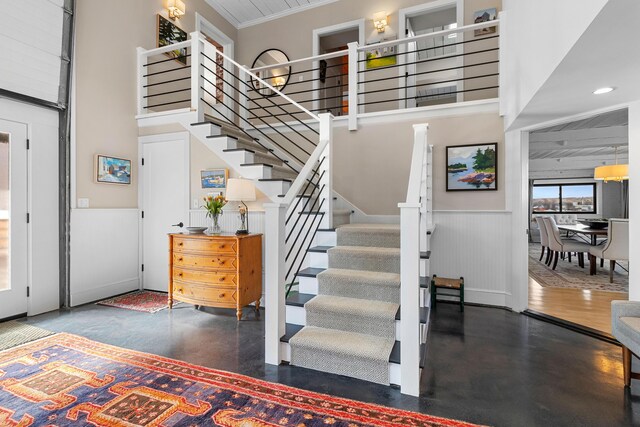 21 Atlantic St, Rockland, ME 04841 - stairs with recessed lighting, wainscoting, a high ceiling, and ornamental molding
