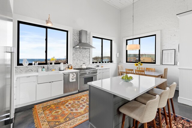 21 Atlantic St, Rockland, ME 04841 - kitchen with a breakfast bar, high quality appliances, wall chimney range hood, a high ceiling, and a sink