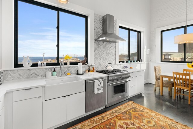 21 Atlantic St, Rockland, ME 04841 - kitchen featuring a sink, wall chimney range hood, appliances with stainless steel finishes, decorative backsplash, and finished concrete floors