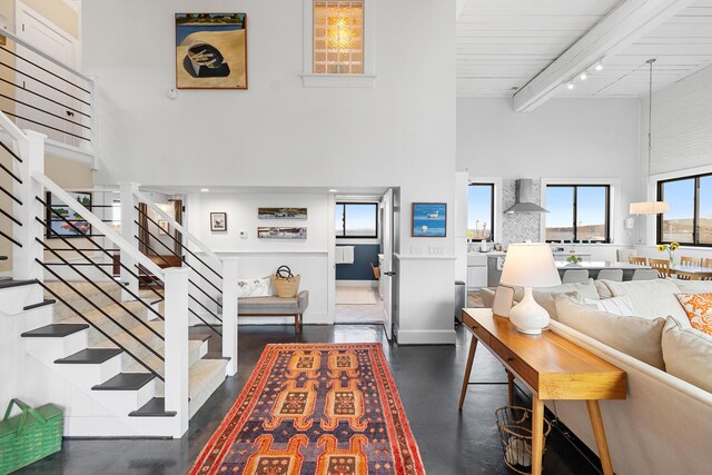21 Atlantic St, Rockland, ME 04841 - living area featuring concrete floors, beam ceiling, stairway, and a towering ceiling