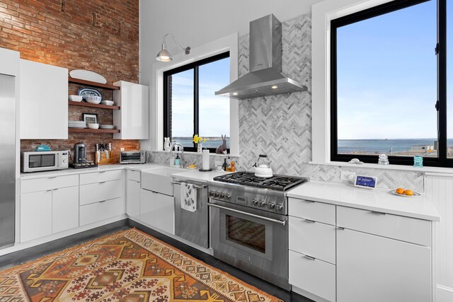 21 Atlantic St, Rockland, ME 04841 - kitchen with open shelves, wall chimney exhaust hood, modern cabinets, stainless steel appliances, and decorative backsplash
