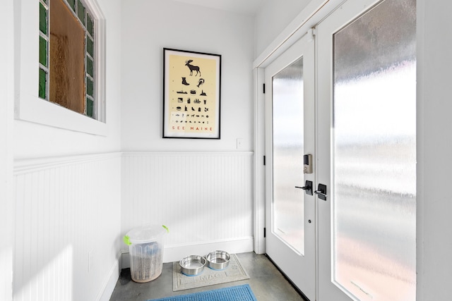 21 Atlantic St, Rockland, ME 04841 - doorway to outside featuring wainscoting, concrete flooring, french doors, and a healthy amount of sunlight