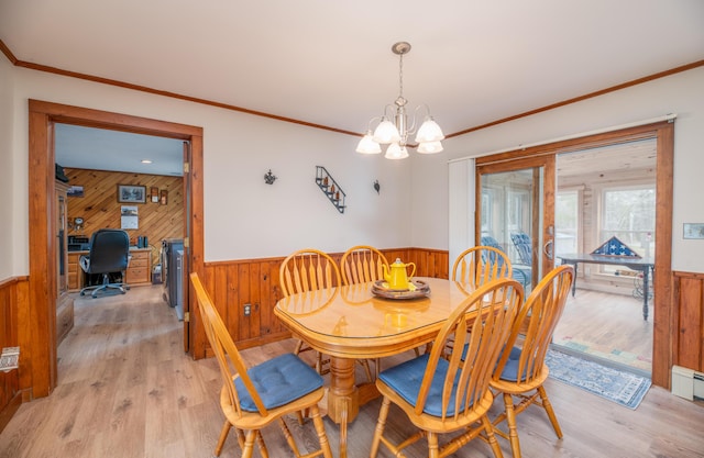 481 Washington Rd, Jefferson, ME 04348 - dining space with a wainscoted wall, light wood finished floors, a chandelier, wooden walls, and ornamental molding