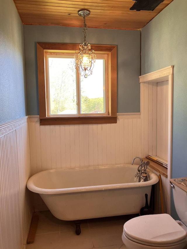 44 Webb Pond Rd, Eastbrook, ME 04634 - bathroom featuring wainscoting, wood ceiling, tile patterned floors, a freestanding tub, and wooden walls