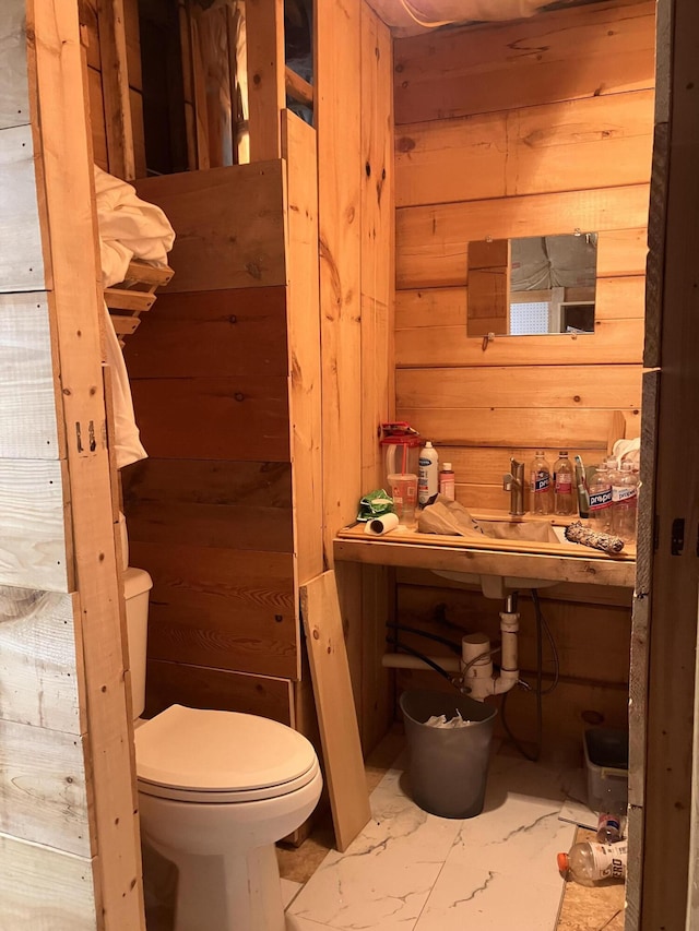 44 Webb Pond Rd, Eastbrook, ME 04634 - half bath featuring wood walls and marble look tile flooring