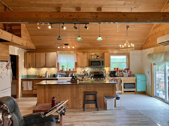 44 Webb Pond Rd, Eastbrook, ME 04634 - kitchen featuring appliances with stainless steel finishes, track lighting, a wall unit AC, plenty of natural light, and lofted ceiling