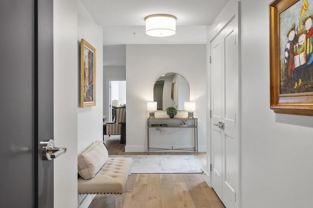 corridor featuring baseboards and light wood-style floors