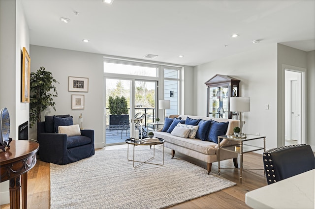 living area with recessed lighting, visible vents, and light wood-style flooring