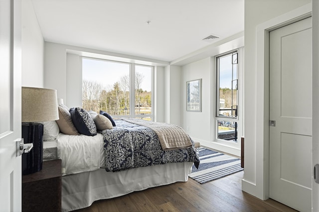 bedroom with visible vents and dark wood-type flooring
