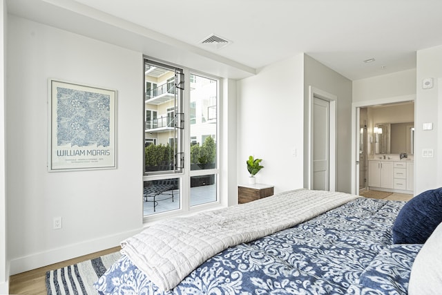 bedroom with baseboards, wood finished floors, and visible vents