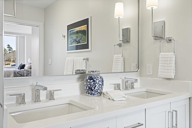 bathroom with double vanity, a sink, and ensuite bath