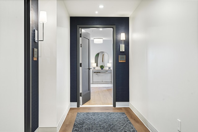 doorway featuring baseboards and wood finished floors