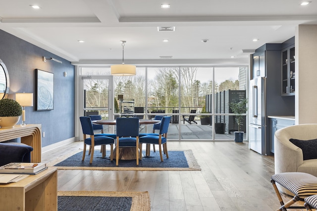 dining space featuring baseboards, wood-type flooring, and visible vents