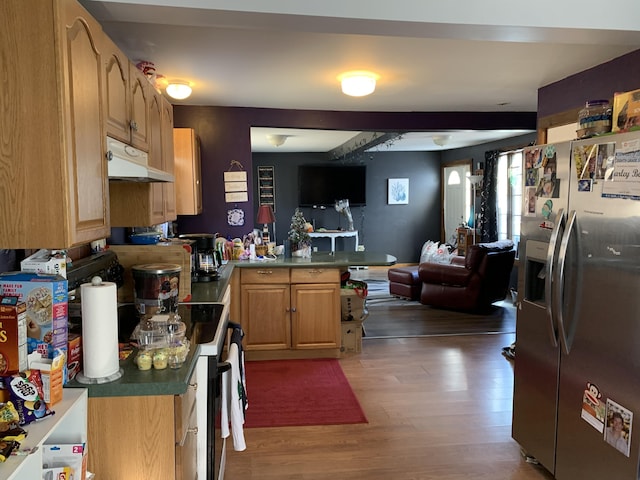 kitchen with stainless steel fridge with ice dispenser, open floor plan, a peninsula, light wood-style floors, and under cabinet range hood