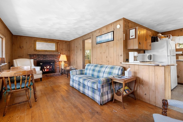 57 Samoset Trl, Boothbay, ME 04544 - living room featuring light wood finished floors, a brick fireplace, and wood walls