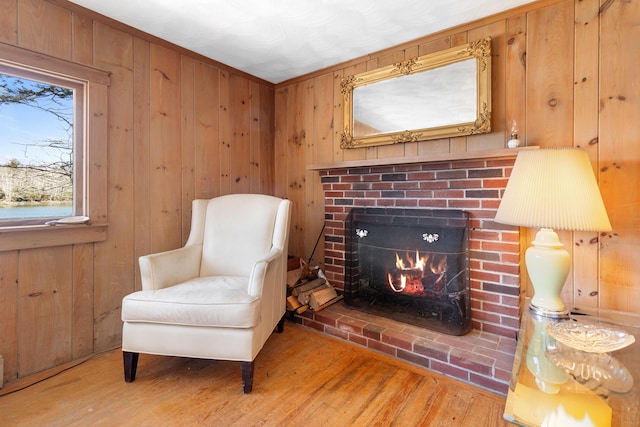57 Samoset Trl, Boothbay, ME 04544 - sitting room with wood walls, a brick fireplace, and wood finished floors