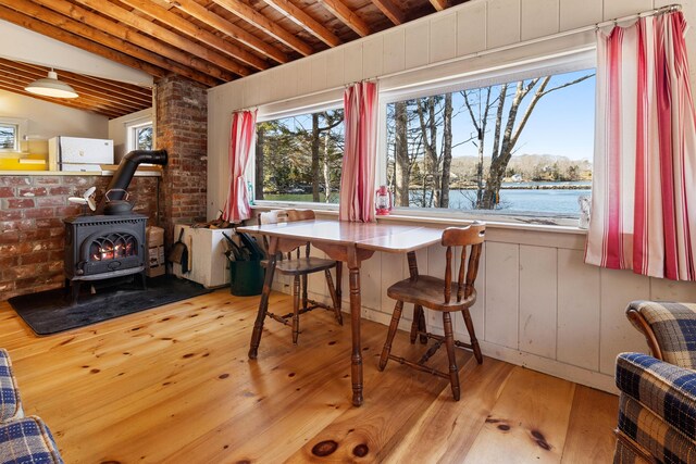 57 Samoset Trl, Boothbay, ME 04544 - dining area with wood-type flooring, a wood stove, and vaulted ceiling with beams