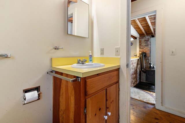 57 Samoset Trl, Boothbay, ME 04544 - bathroom featuring wood finished floors, a wood stove, vanity, beamed ceiling, and wood ceiling