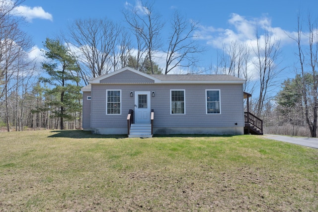 manufactured / mobile home with a front yard, roof with shingles, and entry steps