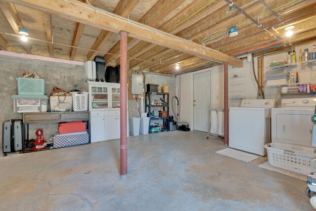 unfinished basement featuring washing machine and clothes dryer and electric panel