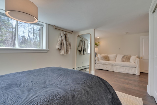 bedroom with baseboard heating and wood finished floors