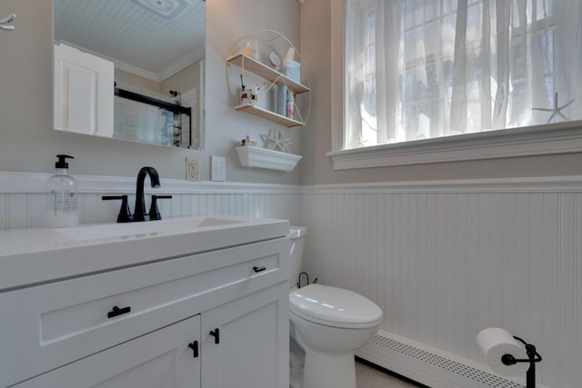bathroom featuring ornamental molding, toilet, a baseboard radiator, wainscoting, and vanity