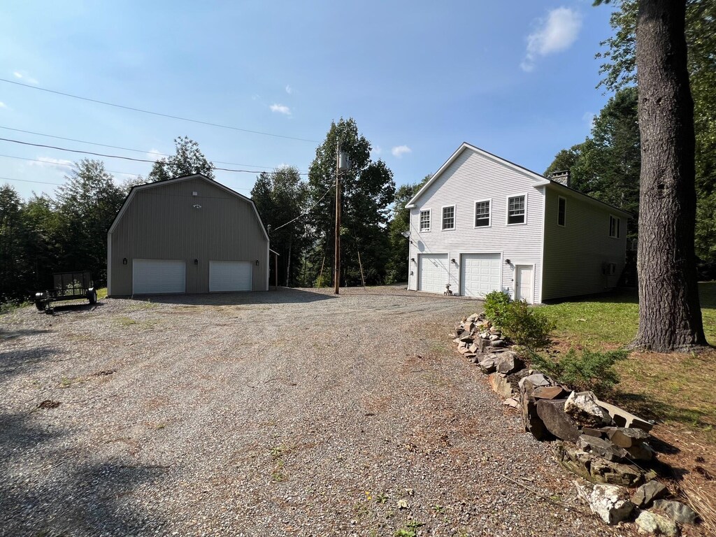 175 Bryant Rd, Saint Albans, ME 04971 - view of property exterior featuring an outdoor structure, a gambrel roof, and a garage