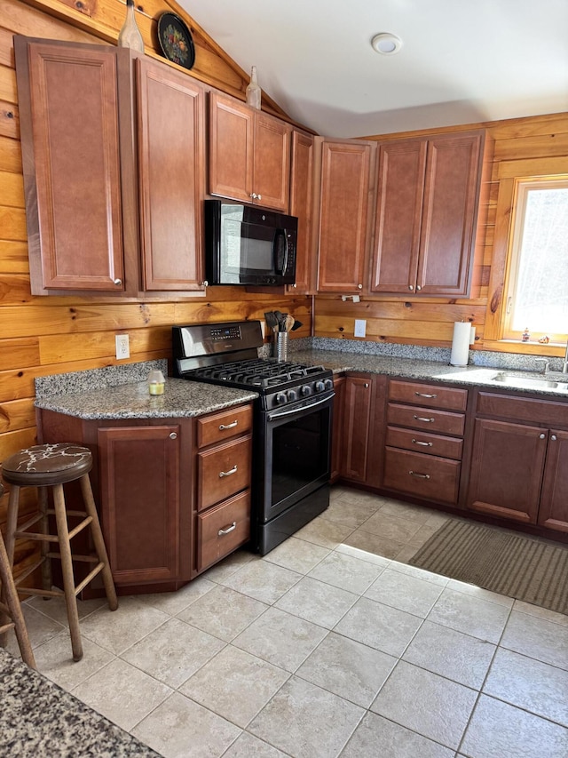 441 Works Rd, Jackson, ME 04921 - kitchen with a sink, dark stone counters, wood walls, stainless steel range with gas cooktop, and black microwave