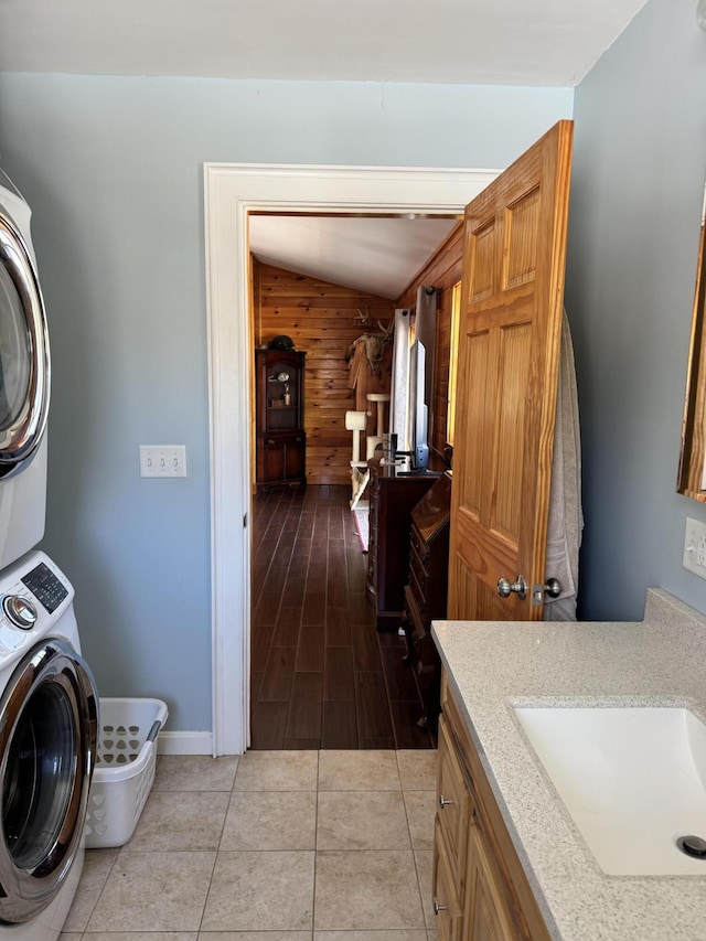 441 Works Rd, Jackson, ME 04921 - laundry room featuring baseboards, a sink, wooden walls, stacked washer / drying machine, and cabinet space