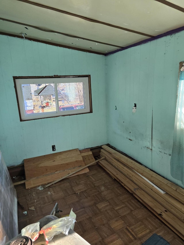unfurnished room featuring wooden walls