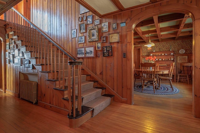 480 Sound Dr, Mount Desert, ME 04660 - staircase featuring arched walkways, hardwood / wood-style flooring, beam ceiling, radiator, and coffered ceiling