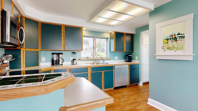 19 Spruce Head Rd, South Thomaston, ME 04858 - kitchen with appliances with stainless steel finishes, a sink, light wood-type flooring, baseboards, and light countertops