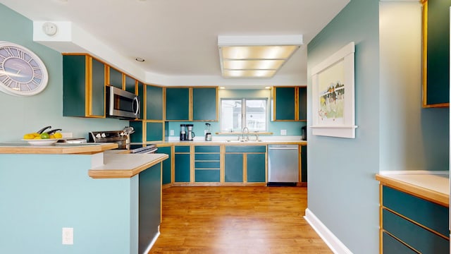 19 Spruce Head Rd, South Thomaston, ME 04858 - kitchen with stainless steel appliances, a sink, light wood-type flooring, light countertops, and glass insert cabinets