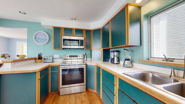 19 Spruce Head Rd, South Thomaston, ME 04858 - kitchen with appliances with stainless steel finishes, light wood finished floors, a sink, a peninsula, and light countertops