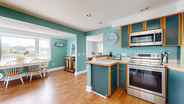 19 Spruce Head Rd, South Thomaston, ME 04858 - kitchen featuring appliances with stainless steel finishes, light countertops, light wood-type flooring, recessed lighting, and a peninsula