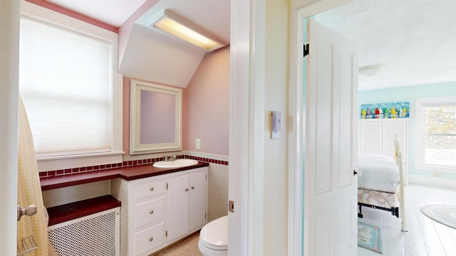 19 Spruce Head Rd, South Thomaston, ME 04858 - bathroom featuring vanity, ensuite bathroom, toilet, tile walls, and vaulted ceiling