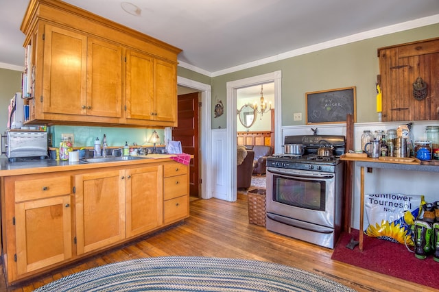 27 Pine St, Eustis, ME 04936 - kitchen featuring stainless steel range with gas cooktop, ornamental molding, wood finished floors, a sink, and wainscoting